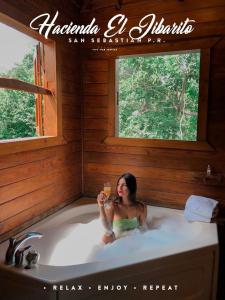 圣塞瓦斯蒂安希巴利托庄园公寓式酒店的坐在浴缸里的女人,喝一杯葡萄酒