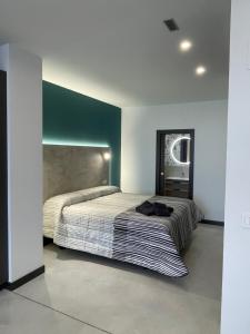 布尔戈斯Apartamentos Aljama的一间卧室设有一张大床和绿色的墙壁