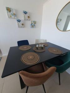 卡尔德拉Casa de descanso的一张黑色餐桌,配有椅子和镜子