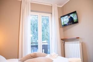 巴多尼奇亚拉贝杜拉酒店的卧室设有窗户,墙上配有电视。