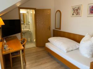 HohenstadtGasthaus Sonne的一间带一张床和一张书桌的卧室以及一间浴室。