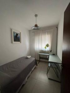 科尔多瓦Alquiler de casa zona Cerro的一间卧室配有一张床、一张书桌和一个窗户。