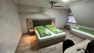 索尔陶吾王酒店 的一间卧室配有两张带绿床单的床和风扇