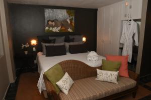 内尔斯普雷特Tranquil Garden Nest的一间卧室配有一张床和一张带枕头的沙发。