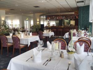 Lubast鲁巴斯特希斯酒店的用餐室配有桌椅和白色桌布