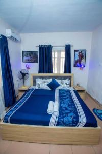 拉各斯AJI Warm 2BED Apartment (Ijegun, Lagos)的一间卧室配有蓝色大床和蓝色床单