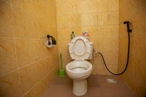 拉各斯AJI Warm 2BED Apartment (Ijegun, Lagos)的一间带卫生间和绿色软管的浴室