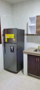 卡利Piazza Granada的厨房配有冰箱,上面有黄色的粘贴纸