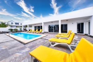 查德尔帕罗奥Casa Eden naturist area, full privacy, relax and private pool的一个带黄色椅子的庭院和一个游泳池