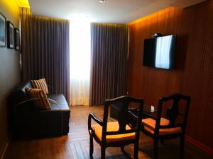 利马拉斯洛马斯酒店的客厅配有两把椅子、一张沙发和一台电视