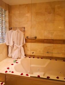 利马拉斯洛马斯酒店的浴室配有带玫瑰花的浴缸,位于柜台上