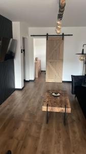 米兹多洛杰Apartament Boho的客厅设有木桌和谷仓门。
