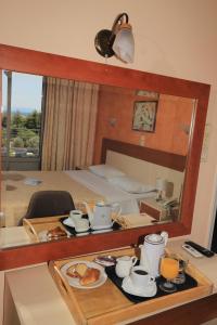 雅典IKAROS Hotel ELLINIKO的酒店客房设有带食物的桌子和镜子