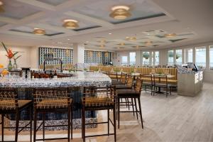 贝瑟尼滩伯大尼海滩海洋套房 - 万豪原住客栈的餐厅设有配备了桌椅的长酒吧