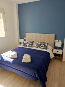 乌贝达Sol Rastro的一间卧室配有一张大床,提供蓝色的床单和枕头