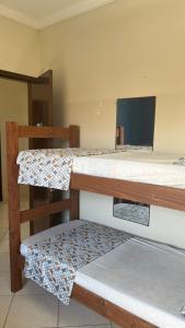 卡波布里奥POUSADA ONDA CARIOCA的客房设有两张双层床和一台平面电视。