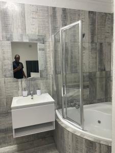 鲁德普特Stay In Carlazo - Unlimited WiFi, Solar backup的一个人拍着一个浴室的照片,浴室里设有水槽和淋浴