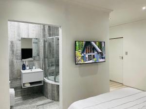 鲁德普特Stay In Carlazo - Unlimited WiFi, Solar backup的一间卧室,浴室的墙壁上配有电视