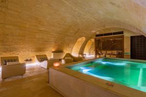 莱切Palazzo Maresgallo Suites & SPA的砖墙内带热水浴池的浴房