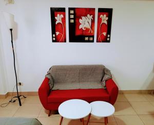 罗萨里奥Catamarca Río的客厅配有红色的沙发和2张桌子