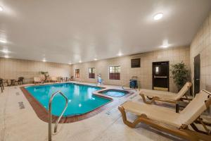 圣安东尼奥SureStay Plus Hotel by Best Western Near SeaWorld San Antonio的酒店客房的大型游泳池配有椅子