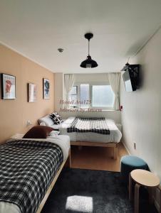 首尔ARA125的一间卧室设有两张床和窗户。