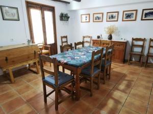MontalbánCasa Roya的一间带桌椅和钢琴的用餐室