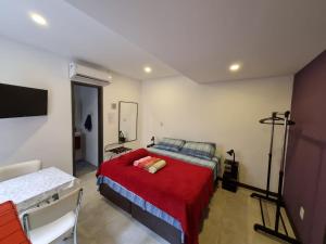 里约热内卢Suítes/Studios Privados Copacabana的一间卧室配有一张带红色毯子的床