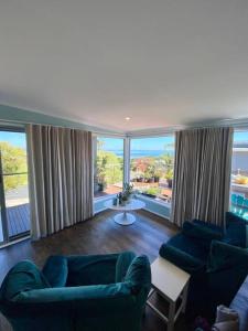 圣雷莫Salty Paws Dog Friendly Luxe Cottage的客厅设有2张蓝色的沙发和大窗户