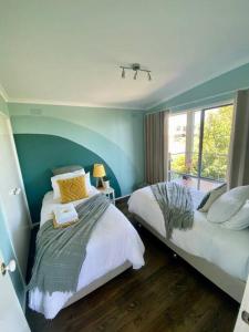 圣雷莫Salty Paws Dog Friendly Luxe Cottage的一间卧室设有两张床和窗户。
