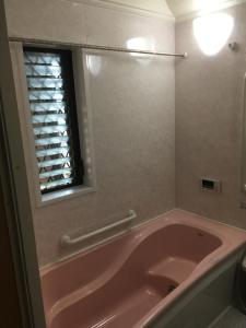 大阪SUMIDA的带窗户的浴室内的粉红色浴缸
