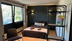 法尔肯堡Bed & Breakfast 'Le Faucon'的一间小卧室,配有双层床和椅子