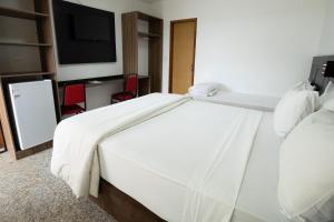 尤西德福拉GH Hotel Express的带电视的酒店客房内的一张白色床