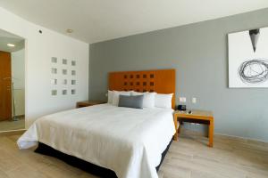 托雷翁Real Inn Torreon的卧室配有一张白色的大床和一张桌子
