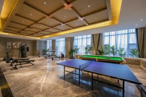 彭泽彭泽远洲轩廷酒店的一间设有两张乒乓球桌的泳池间
