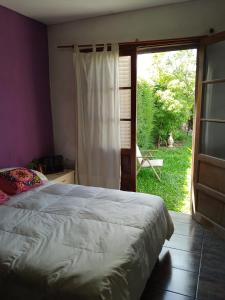 GualeguaychúComo en casa的一间卧室设有一张床和一个滑动玻璃门