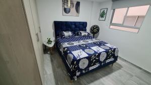 伊瓦格Hermoso Apartamento Entero - Parqueadero - Ibague - Roble的一间卧室设有蓝色的床和窗户。