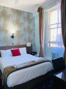 奥克兰艾斯普奈酒店的一间卧室配有一张带红色枕头的床和一扇窗户