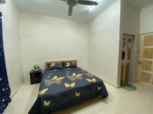 阿罗士打CMS HOMESTAY ALOR SETAR的一间卧室配有一张带蓝毯和蝴蝶的床