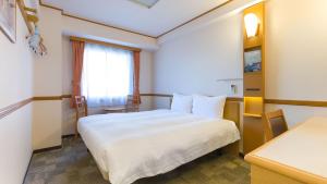 带广Toyoko Inn Hokkaido Tokachi Obihiro Ekimae的酒店客房设有白色的床和窗户。