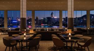 香港香港丽晶酒店的一间设有桌椅的餐厅,享有城市美景