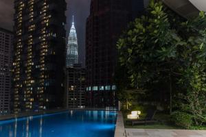 吉隆坡Bukit Bintang Signatures by Premium Hospitality的一座晚上拥有城市天际线的游泳池