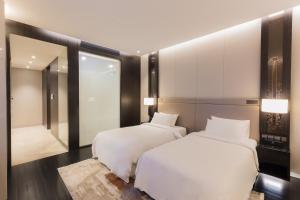 吉隆坡Bukit Bintang Signatures by Premium Hospitality的一间卧室配有两张床和镜子