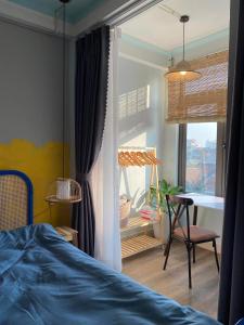 河内Homestay Casa 69的一间卧室配有一张床、一张桌子和一个窗户。