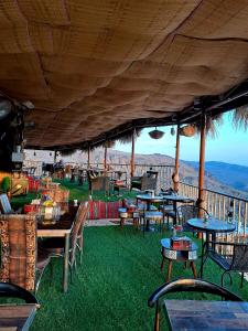 Misfāh阿尔密斯法温馨旅馆的室外餐厅,在草地上摆放着桌椅