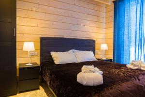 休钦斯克Park Hotel Kokshetau的一间卧室配有一张带两盏灯和毛巾的床。
