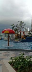 马六甲bali residensi的游泳池配有红色和黄色的雨伞和水
