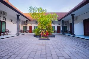 库塔Kos Bulan Bali的一座两棵树成盆的建筑的庭院
