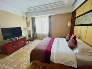 南京Jinling Jingyuan Plaza的配有一张床和一台平面电视的酒店客房