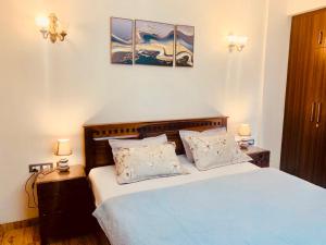 德拉敦Hill Nest with a serene view的一间卧室配有一张蓝色的床,配有两个床头柜和两盏灯
